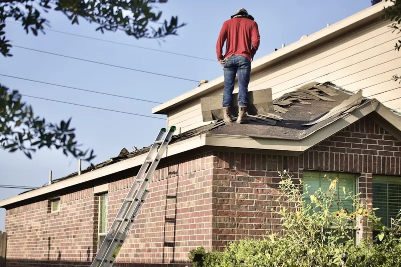 Professional roofer working on a residential roof in Asbury